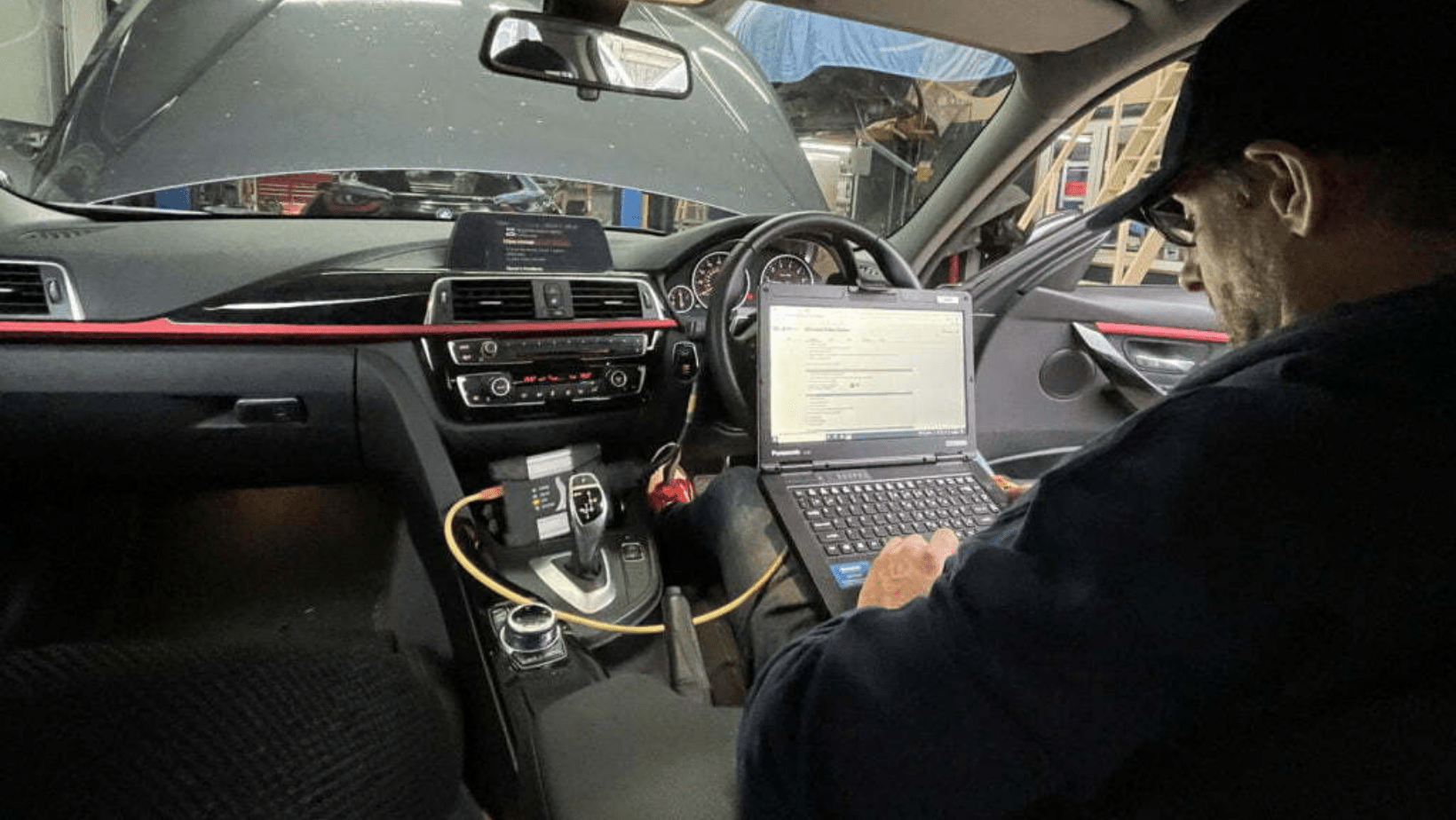 Technician on laptop in vehicle